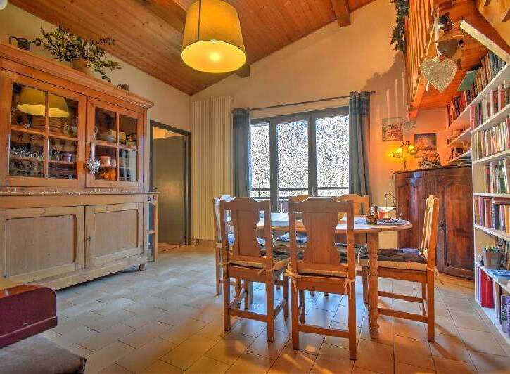 Step into this charming dining room, featuring a rustic wooden cabinet and a cozy dining set.