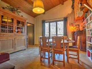 Step into this charming dining room, featuring a rustic wooden cabinet and a cozy dining set.