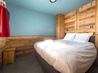 This cozy bedroom features a rustic wooden accent wall, creating a warm and inviting atmosphere.