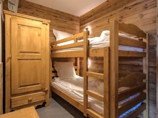 This cozy bedroom features a charming bunk bed, perfect for accommodating guests or family members.