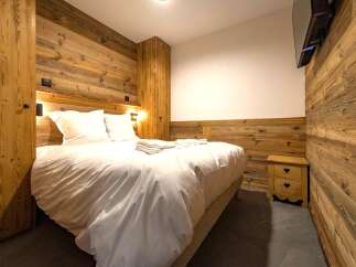 This cozy bedroom features stunning wood paneling that adds warmth and character to the space.