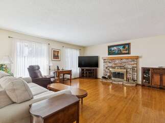 Step into this inviting living room, featuring a cozy fireplace and a large flat-screen TV, perfect for entertaining or relaxing.