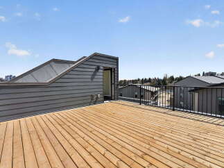 Enjoy breathtaking views from this stunning rooftop deck! This property features a spacious wooden deck, perfect for entertaining or relaxing.