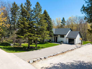 This stunning property boasts a modern white exterior and a sleek black roof, offering a contemporary aesthetic.