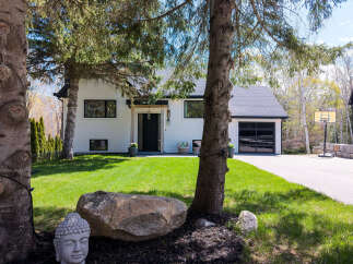 This stunning property boasts a modern aesthetic with its crisp white exterior and sleek black accents.