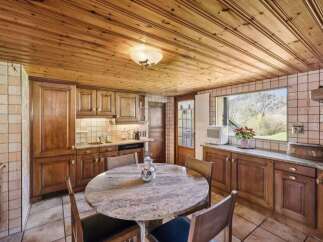 This charming kitchen features a warm, inviting atmosphere with its wooden ceiling and cabinetry.
