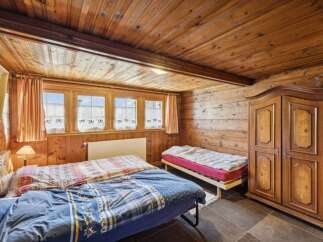 Step into this charming bedroom featuring rustic wooden paneling and a cozy atmosphere.