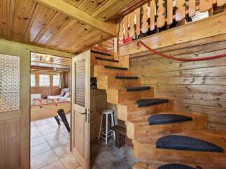 Step into rustic charm with this inviting property! Featuring a unique wooden staircase and cozy interior, this home offers a warm and welcoming atmosphere.