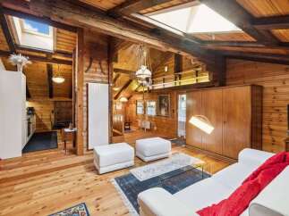 Step into rustic elegance with this stunning property, showcasing a warm, inviting interior with exposed wooden beams and paneling.