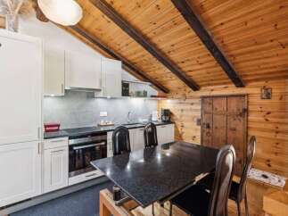 This charming kitchen features a rustic design with wooden walls and ceiling, creating a warm and inviting atmosphere.