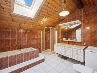 Step into this charming bathroom, featuring a unique sloped ceiling with a skylight that floods the space with natural light.