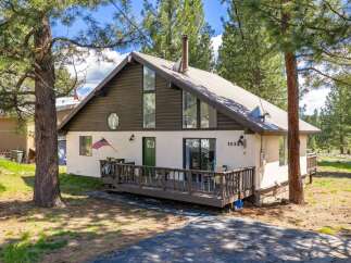 Nestled amidst towering trees, this charming home offers a serene escape.