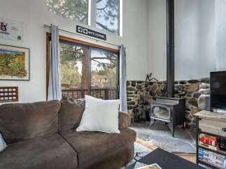 Cozy up in this charming living room featuring a stone fireplace and a comfortable sofa.