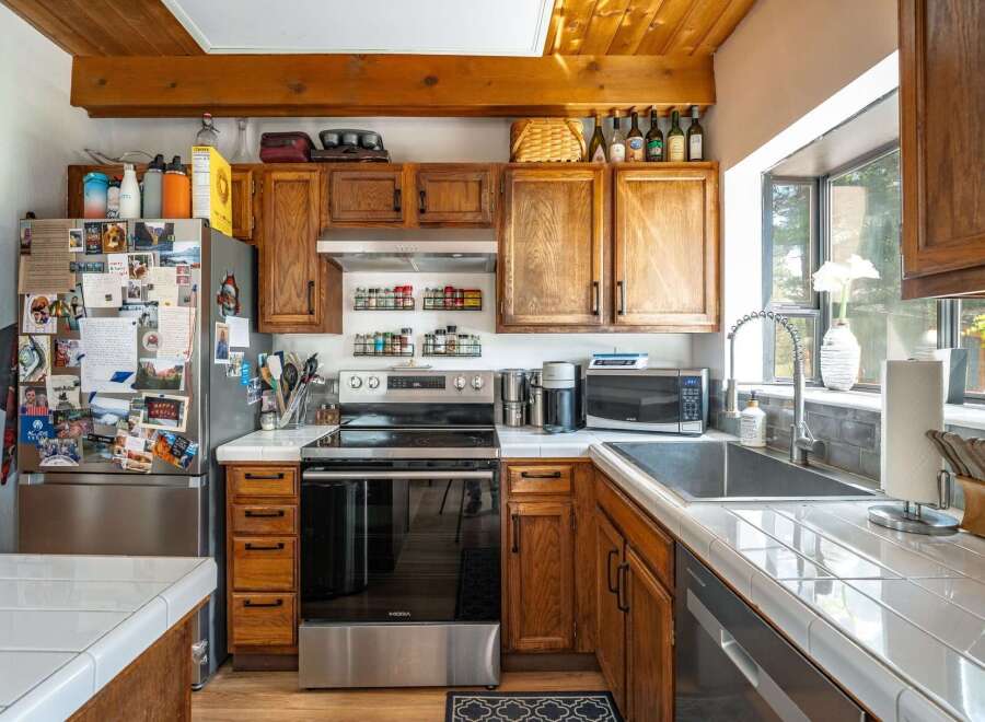 This charming kitchen boasts warm wooden cabinetry and a stainless steel oven, creating a cozy and inviting atmosphere.