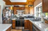 This charming kitchen boasts warm wooden cabinetry and a stainless steel oven, creating a cozy and inviting atmosphere.