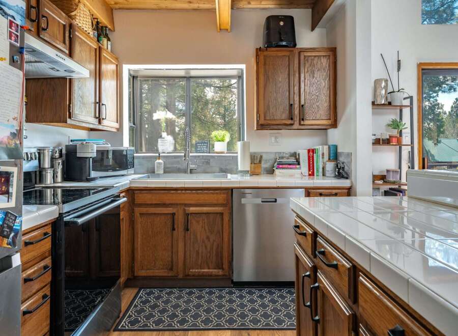 This charming kitchen boasts warm wooden cabinetry and a stainless steel dishwasher, creating a welcoming atmosphere.