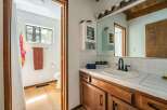 Step into this charming bathroom, featuring a warm wooden vanity and a bright, inviting atmosphere.