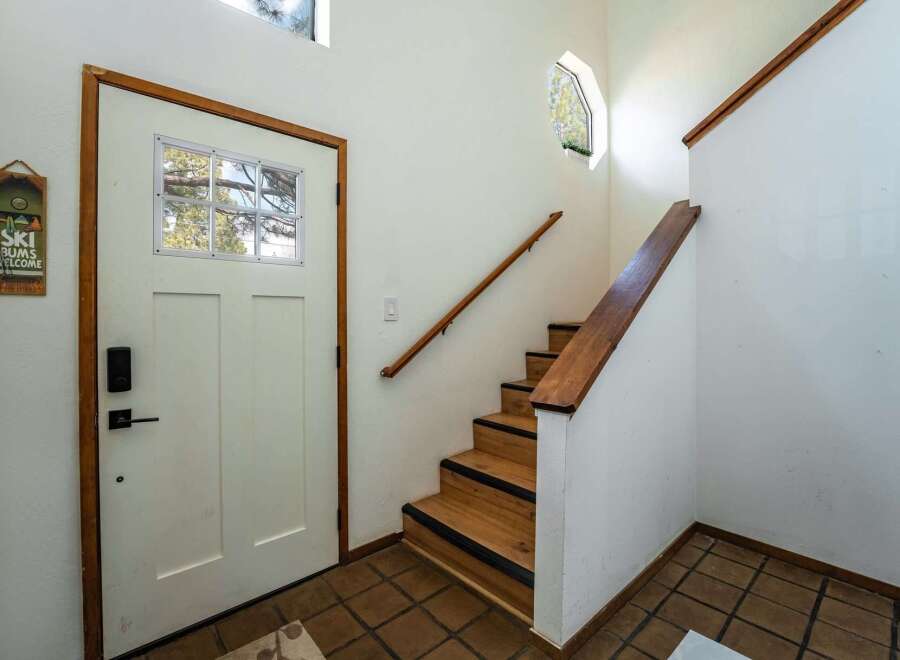 Step into this inviting entryway featuring a charming staircase and a welcoming front door.