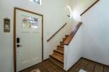 Step into this inviting entryway featuring a charming staircase and a welcoming front door.