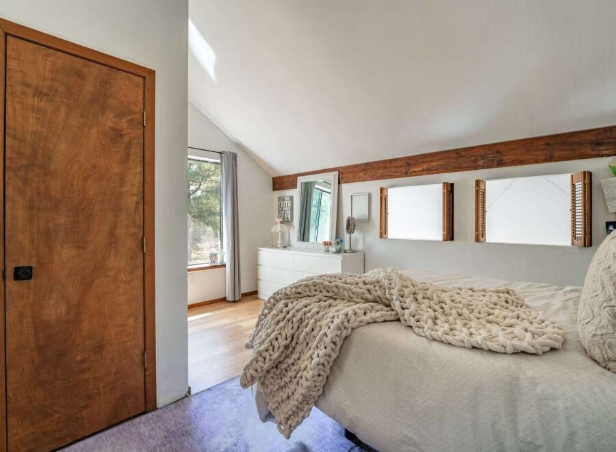 This charming bedroom features a cozy atmosphere with a plush, oversized blanket draped over the bed.
