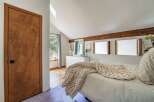 This charming bedroom features a cozy atmosphere with a plush, oversized blanket draped over the bed.