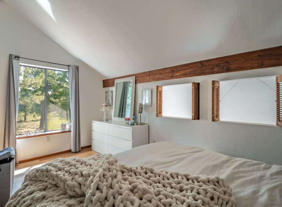 This inviting bedroom boasts a cozy atmosphere with its neutral color palette and natural light.