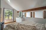 This inviting bedroom boasts a cozy atmosphere with its neutral color palette and natural light.