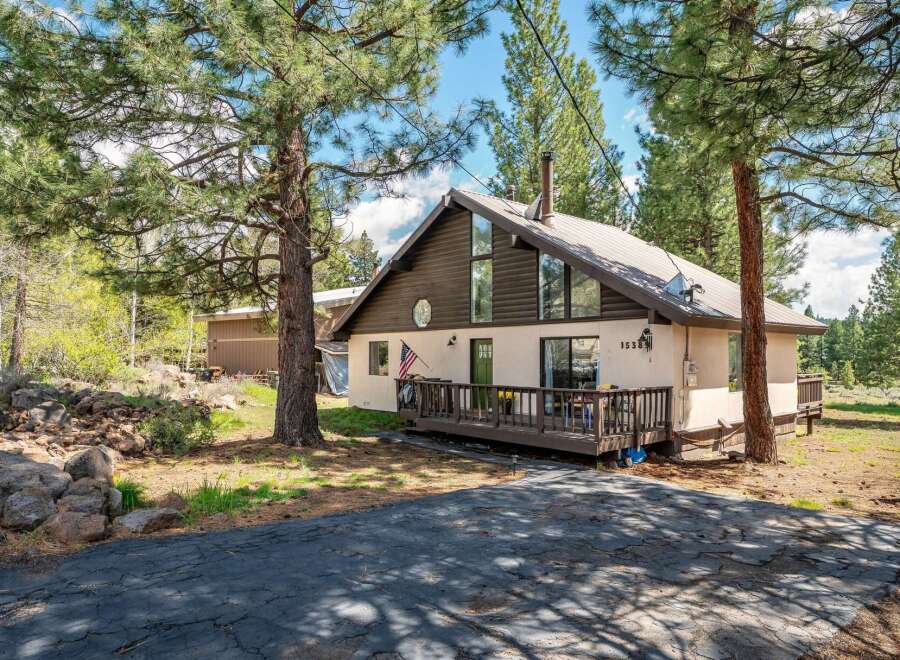 Nestled amidst towering trees, this charming home offers a serene escape.