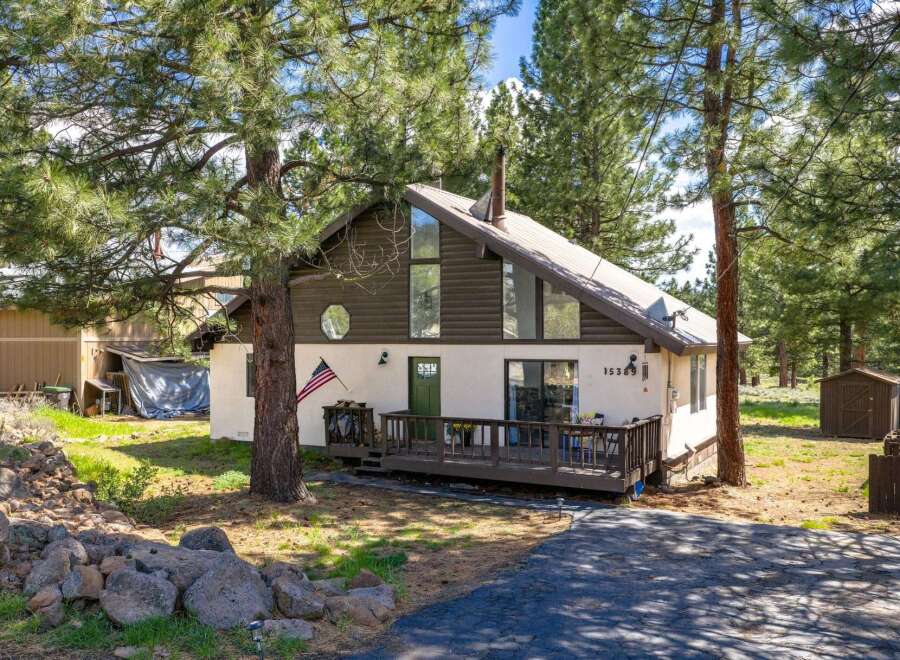 Nestled amidst towering trees, this charming home offers a serene retreat.