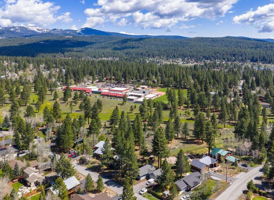 Discover a stunning property nestled in a picturesque landscape, surrounded by lush greenery and towering trees.