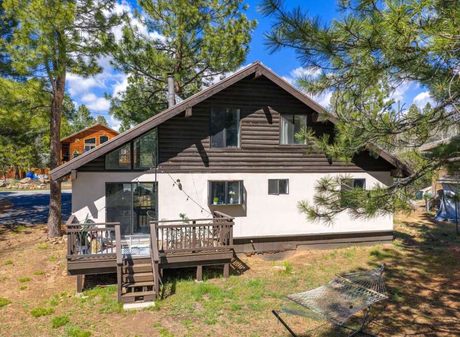 Nestled amidst towering trees, this charming home offers a serene retreat.