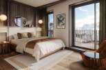 Experience luxury living in this stunning bedroom with breathtaking mountain views.