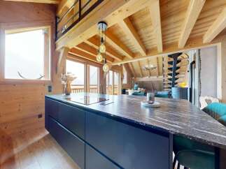 Experience luxury living in this stunning chalet, featuring a modern kitchen with sleek countertops and ample storage.