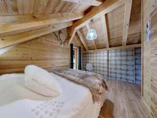 This stunning bedroom boasts a rustic charm with its wooden walls and ceiling, creating a warm and inviting atmosphere.