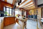 Step into rustic elegance with this stunning kitchen! Featuring exposed wooden beams, a charming wooden island, and a cozy dining area, this space is perfect for both cooking and entertaining.