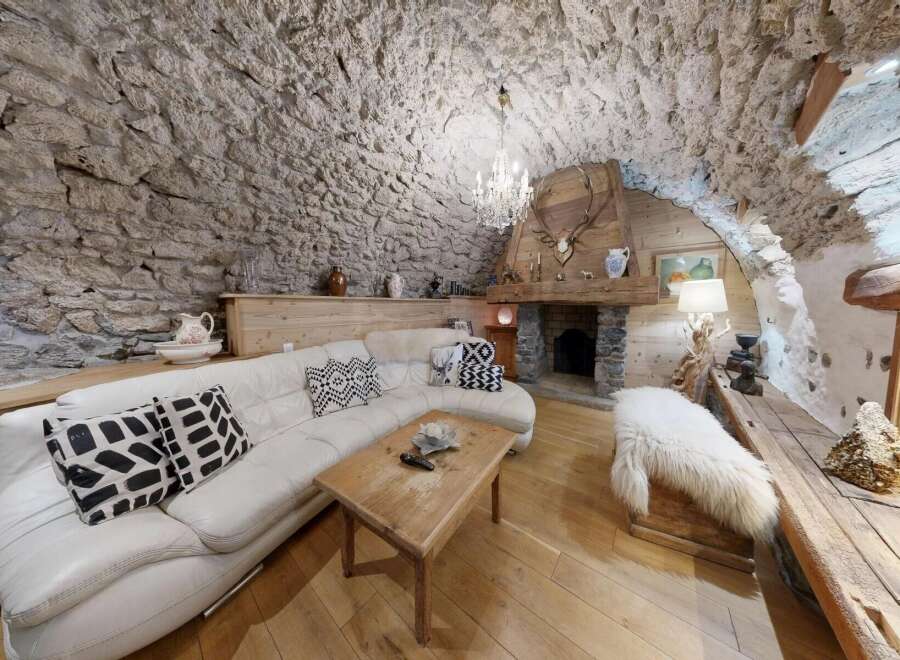 Step into rustic elegance with this stunning property, featuring a unique stone-walled interior and a cozy fireplace.