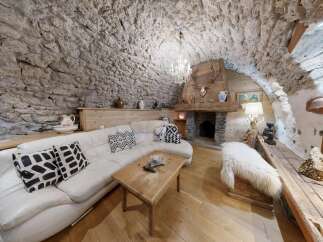 Step into rustic elegance with this stunning property, featuring a unique stone-walled interior and a cozy fireplace.
