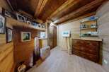 This charming property boasts a rustic interior with wooden walls and ceilings, creating a warm and inviting atmosphere.