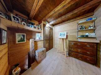 This charming property boasts a rustic interior with wooden walls and ceilings, creating a warm and inviting atmosphere.