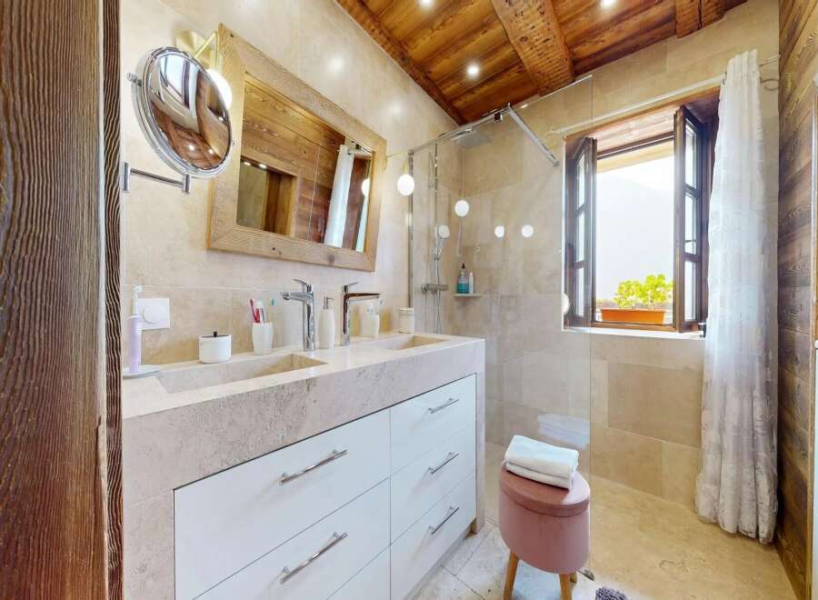 Step into luxury with this stunning bathroom featuring a double vanity and a spacious shower.