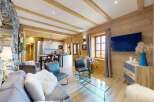 Experience the charm of this stunning property, featuring a beautifully designed living space with exposed wooden beams and a cozy stone wall.