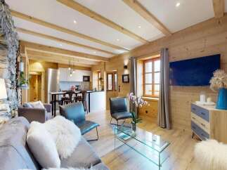Experience the charm of this stunning property, featuring a beautifully designed living space with exposed wooden beams and a cozy stone wall.