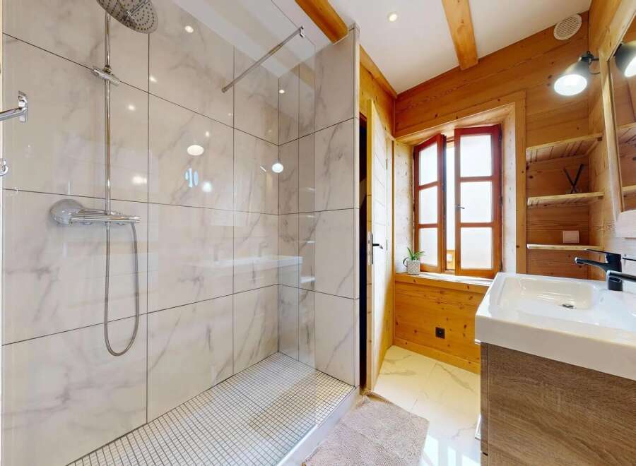 Step into a luxurious bathroom retreat! This stunning space features a modern shower with elegant marble-like tiles, complemented by a stylish vanity.