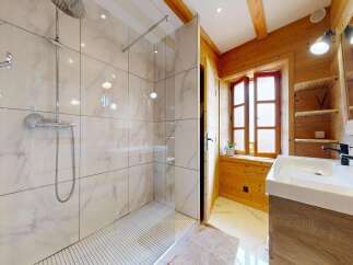 Step into a luxurious bathroom retreat! This stunning space features a modern shower with elegant marble-like tiles, complemented by a stylish vanity.