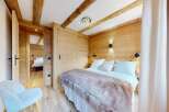 Step into this cozy bedroom, featuring stunning wooden accents and a warm, inviting atmosphere.