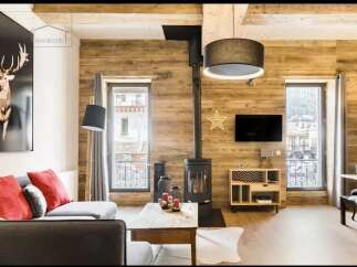 Experience the charm of this stunning property, featuring a cozy living room with a modern fireplace and a stylish wooden accent wall.