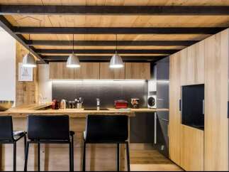 Discover modern living in this stunning kitchen! Featuring a unique wooden ceiling and sleek black accents, this space is perfect for both cooking and entertaining.