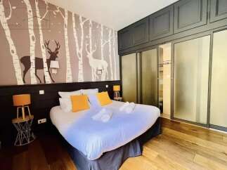 Discover this charming bedroom featuring a unique forest-themed accent wall and a comfortable bed.