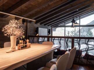Experience luxury living in this stunning property, featuring a beautifully designed dining area with a rustic wooden table and elegant seating.