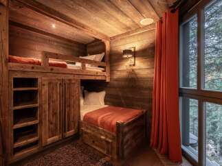 Step into a cozy mountain retreat with this charming bedroom featuring custom-built bunk beds.